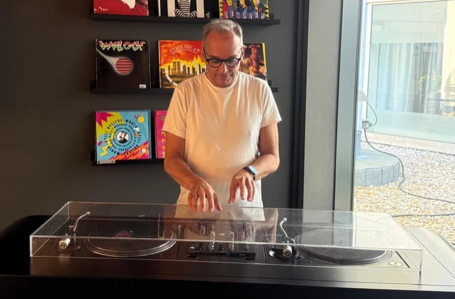 Wolfgang beim Auflegen, im Hintergrund Plattencover